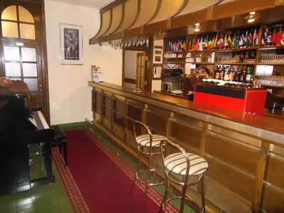 a bar with three stools sitting at the counter at Hotel Pri Belokranjcu in Novo Mesto
