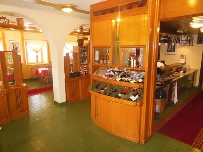 a room with a shop with wooden cabinets and a counter at Hotel Pri Belokranjcu in Novo Mesto
