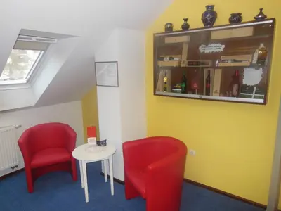 a waiting room with two red chairs and a table at Hotel Pri Belokranjcu in Novo Mesto