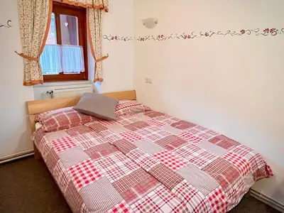 a bedroom with a bed with a checkered blanket at Al-Pine Apartment in Kranjska Gora