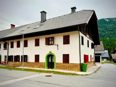 a large white building with a black roof at Al-Pine Apartment in Kranjska Gora