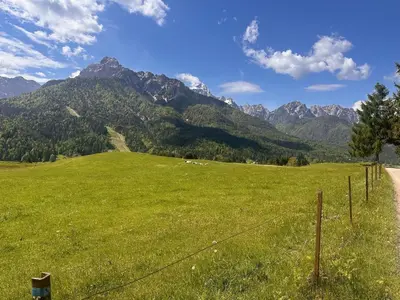 a field of green grass with mountains in the background at Nordic Sun 1 in Kranjska Gora