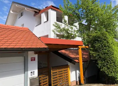 a house with a red roof and a garage at Apartments Marja in Slovenj Gradec
