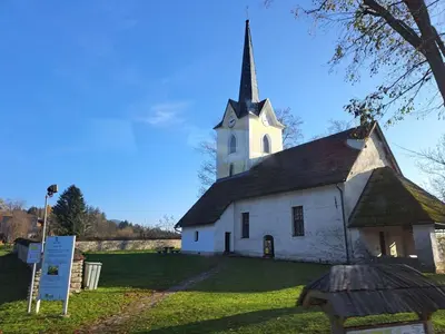 an old white church with a steeple on a field at Apartments Marja in Slovenj Gradec