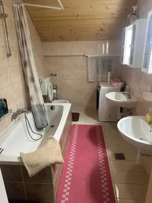 a bathroom with a large tub and a sink and a tub at Apartments Marja in Slovenj Gradec
