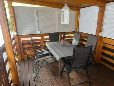 a table and chairs on the porch of a cabin at Apartments Marja in Slovenj Gradec