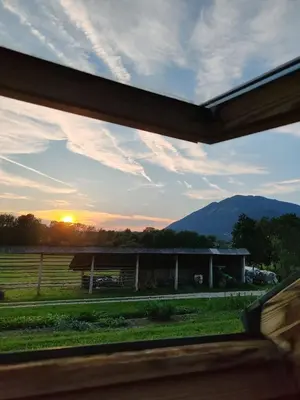 a view of a barn with the sunset in the background at Apartment Katja in Križe