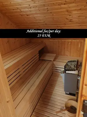a sauna with wooden floors and a sign that reads additional fee for day at Apartment Katja in Križe