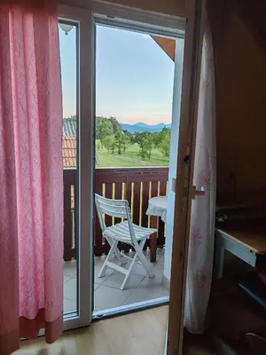 a white chair on a balcony with a window at Apartment Katja in Križe