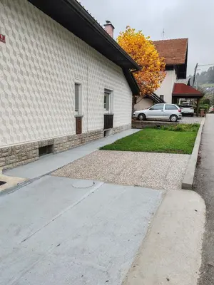 a sidewalk next to a house with a car parked at Apartment Katja in Križe