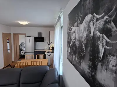 a living room with a couch and a painting of a moose at 3 JABLANE apartmaji in Beltinci