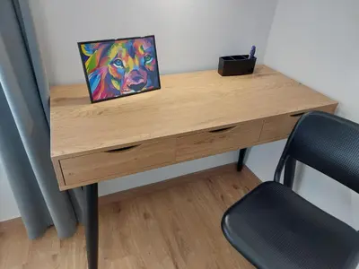 a wooden desk with a painting on it next to a chair at 3 JABLANE apartmaji in Beltinci
