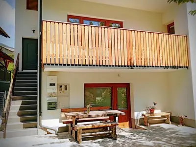 a house with a balcony and a table and a sink at Apartma Discovering Slovenia in Luče