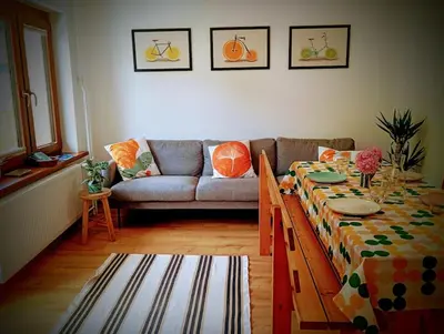 a living room with a table and a couch at Apartma Discovering Slovenia in Luče