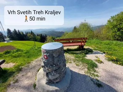 a bench sitting next to a rock pillar next to a field at Tiny house in Žiri