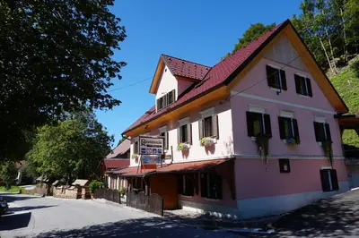 a pink and white building on a street at Uaštarie u Luogu in Cerkno