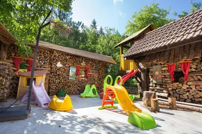 a playground with a bunch of play equipment in front of a building at Uaštarie u Luogu in Cerkno