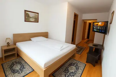 a small bedroom with a bed and a television at Uaštarie u Luogu in Cerkno