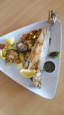 a plate of food with a fish and vegetables at Rosa Bed and Breakfast in Podgorje