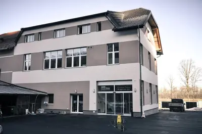 a building with a parking lot in front of it at Rosa Bed and Breakfast in Podgorje