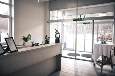 a lobby with a counter with a table and windows at Rosa Bed and Breakfast in Podgorje