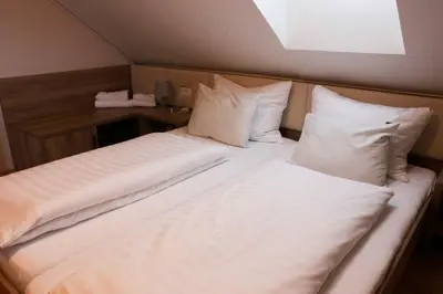 a large bed with white sheets and pillows at Homestay Sreš in Mlaka pri Kranju