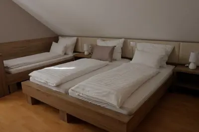 two twin beds in a room with two tables at Homestay Sreš in Mlaka pri Kranju