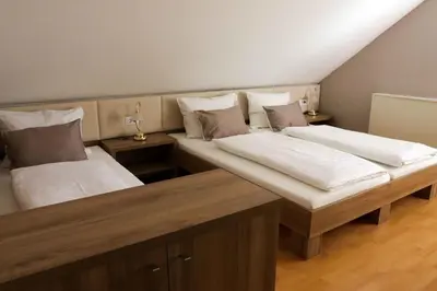 two twin beds in a room with wooden floors at Homestay Sreš in Mlaka pri Kranju