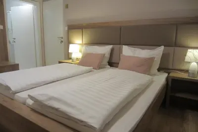 a large bed with white sheets and pink pillows at Homestay Sreš in Mlaka pri Kranju
