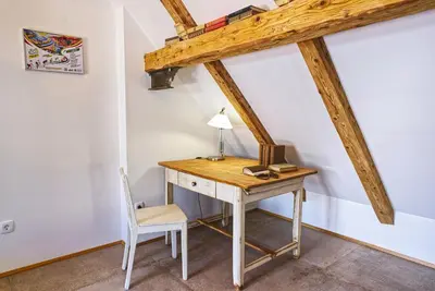 a desk with a lamp and a chair in a room at House Tinka Bled in Bled