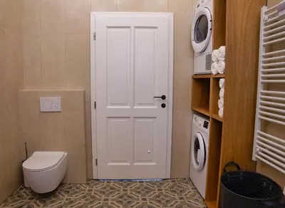 a bathroom with a toilet and a washing machine at House Tinka Bled in Bled
