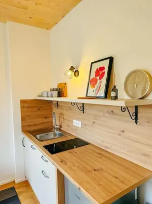 a kitchen with a counter with a sink and a clock at Apartment Kovacic - Lake Bled in Bled