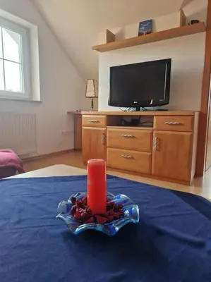 a candle sitting on top of a bed with a tv at Apartma Aurora in Hraše