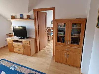 a living room with a television and a wooden cabinet at Apartma Aurora in Hraše