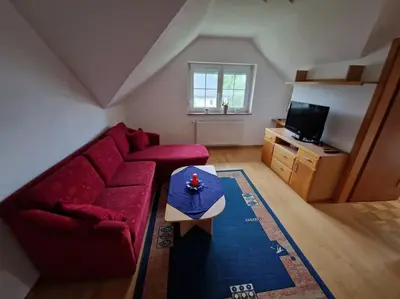 a living room with a red couch and a table at Apartma Aurora in Hraše