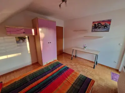 a bedroom with a pink cabinet and a table at Apartma Aurora in Hraše