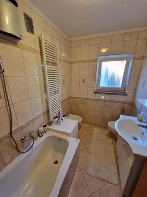 a bathroom with a tub and a sink and a toilet at Apartma Aurora in Hraše