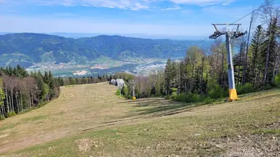 a grassy hill with a ski lift tower on it at Apartma Tanja bike-friendly in Limbuš