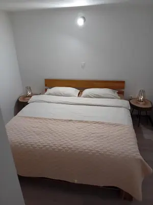 a bedroom with a large white bed with two tables at Apartma - Hiša Zofija in Slovenske Konjice