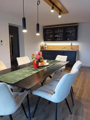 a kitchen with a wooden table and white chairs at Apartma - Hiša Zofija in Slovenske Konjice