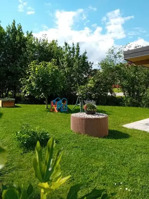 a park with a table in the grass with a playground at Apartma - Hiša Zofija in Slovenske Konjice