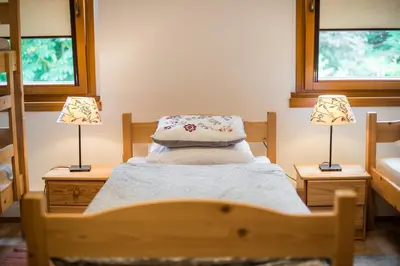 a small bedroom with a bed and two lamps at Rooms Kozmus in Brestanica
