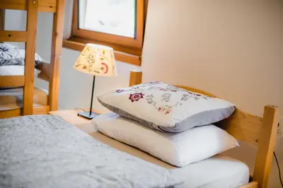 a stack of pillows on a table in a bedroom at Rooms Kozmus in Brestanica