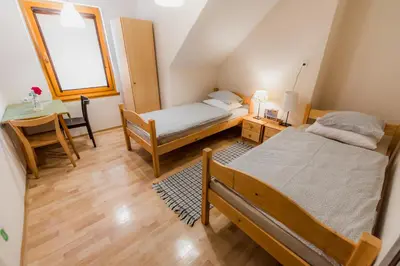 a bedroom with two beds and a table and a window at Rooms Kozmus in Brestanica