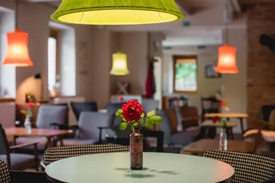 a flower in a vase on a table in a restaurant at Rooms Kozmus in Brestanica