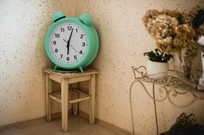 a green clock sitting on a table next to a wall at Rooms Kozmus in Brestanica