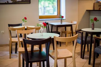 a restaurant with tables and chairs with flowers on them at Rooms Kozmus in Brestanica