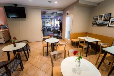 a restaurant with tables and chairs and a tv at Rooms Kozmus in Brestanica