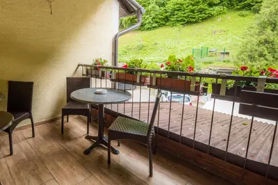 a balcony with a table and chairs and a window at Rooms Kozmus in Brestanica