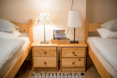 a bedroom with two beds and a lamp on a night stand at Rooms Kozmus in Brestanica